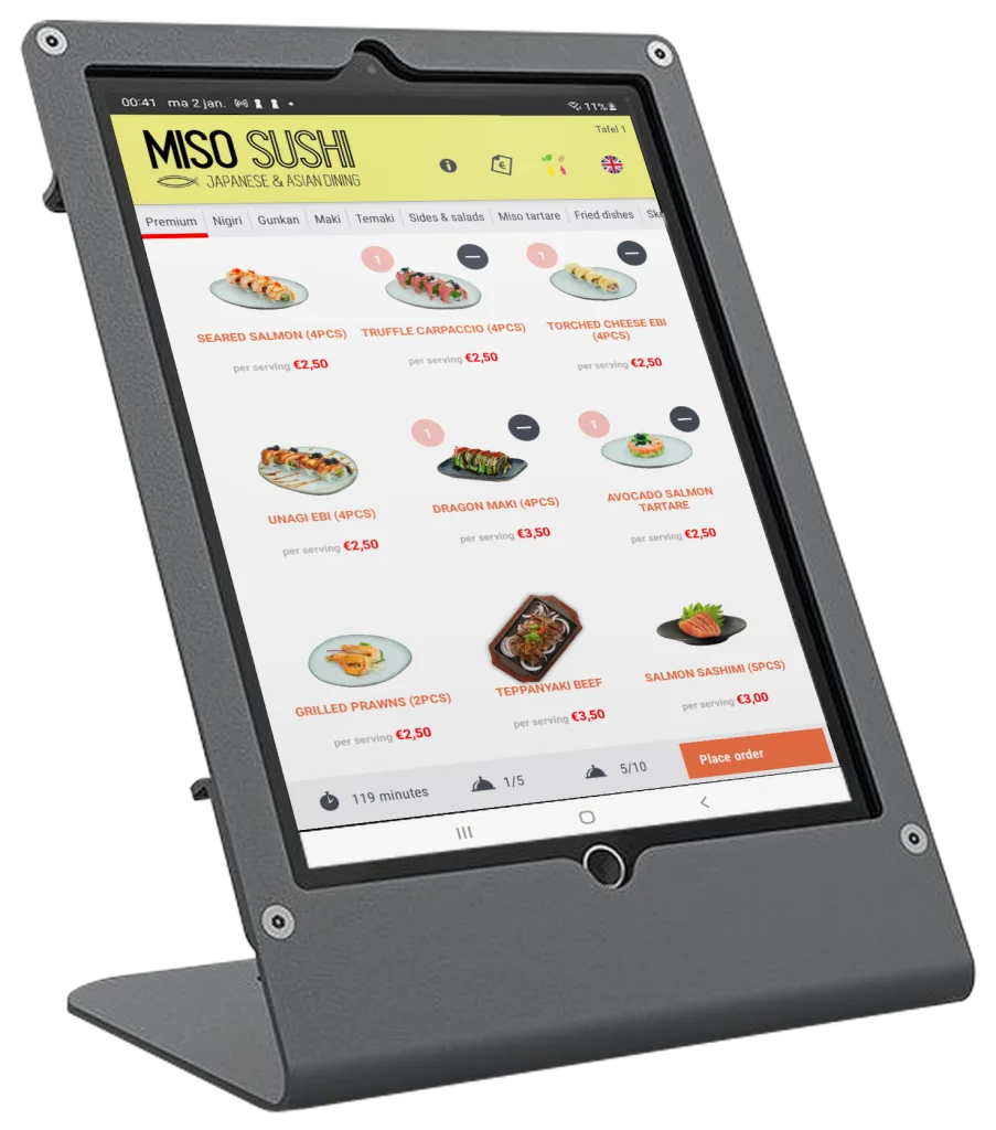 Een tablet met Foodyx Tablet Menu in een tafelstandaard. Op het scherm staat de menukaart van een restaurant: categorieën bovenaan, gerechten met foto en prijs, en onderaan de knop Place order.